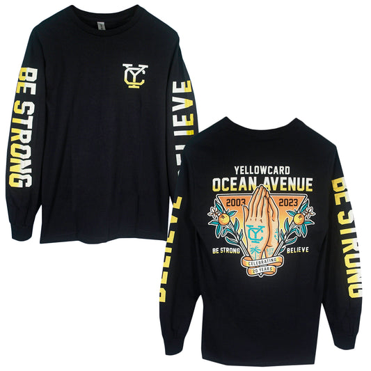 The Believe - Black Long Sleeve is printed on Gildan Ultra Cotton and features BE STRONG and BELIEVE on the sleeves, a yellow YC logo on the front, plus praying hands with YELLOWCARD OCEAN AVENUE 2003–2023 on the back.