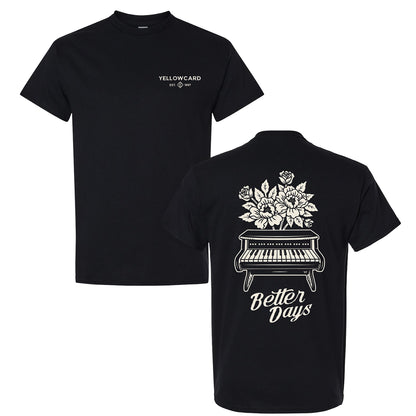 The Better Days Piano - Black T-Shirt features Yellowcard and EST. 1997 in white on the front left chest, a piano with blooming flowers and "Better Days" in white script on the back. Classic fit, 100% cotton.