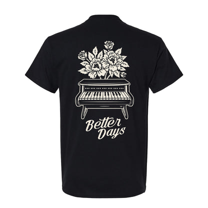 The Better Days Piano - Black T-Shirt is a classic-fit, 100% cotton tee featuring a piano with flowers and "Better Days" on the back. Perfect for everyday comfort.