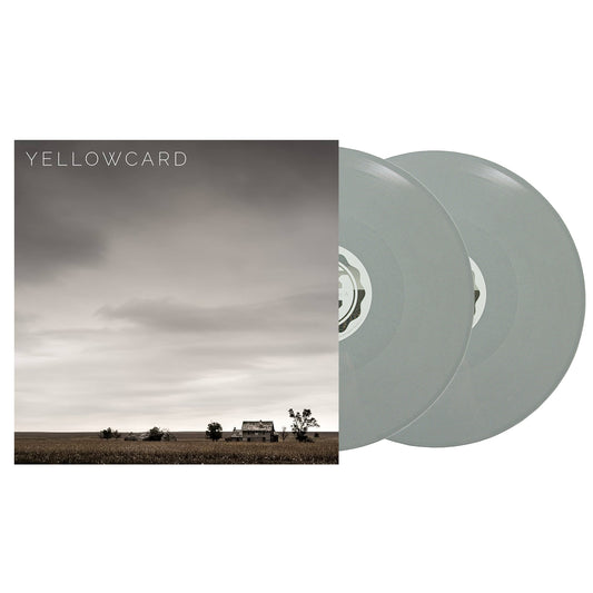 Two gray Self Titled - 2xVinyl LP records beside an album cover showing a cloudy sky over a farmhouse landscape. Features tracks like "Rest In Peace" and "Fields & Fences." Yellowcard is printed in white at the top left.